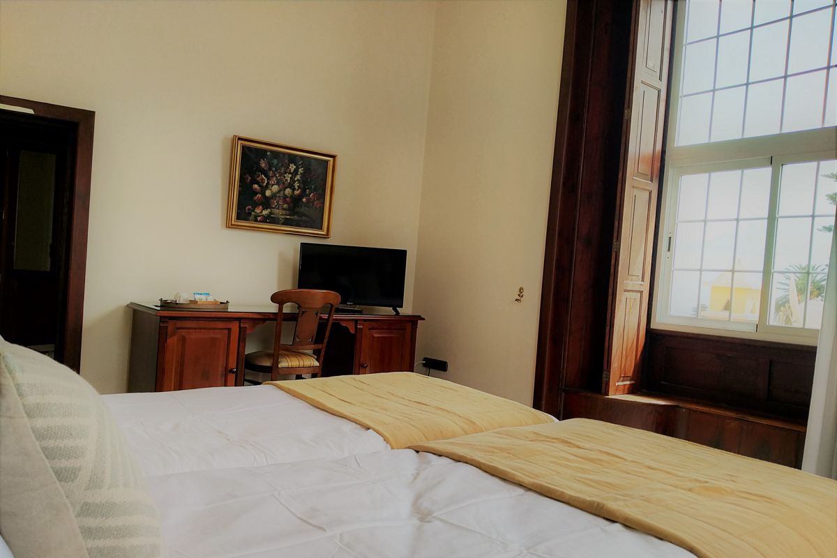 Habitación con cama doble, escritorio y ventana en La Orotava, Tenerife.