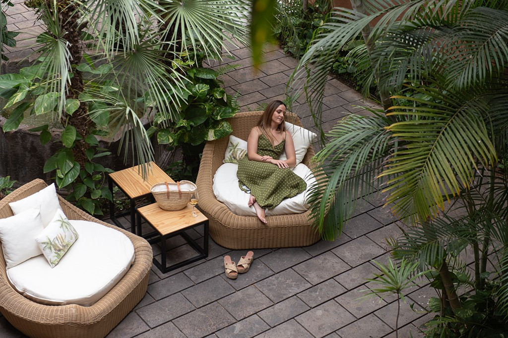 Persona relajándose en un patio rodeado de palmeras en Tenerife.