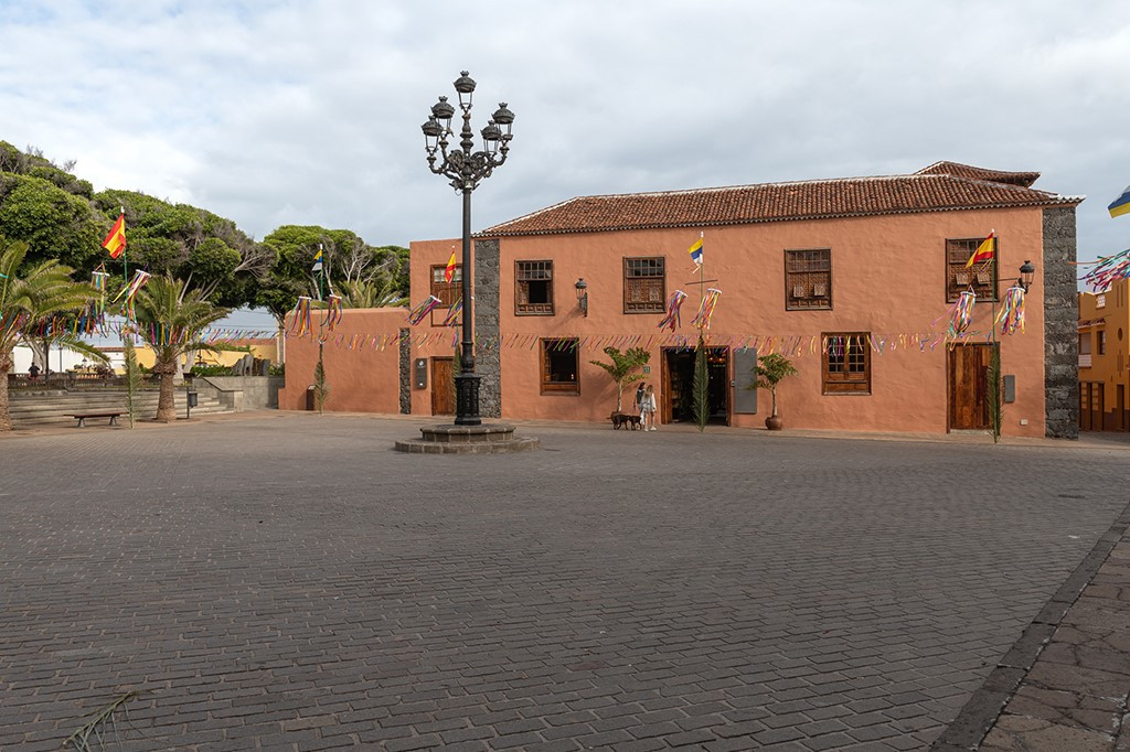 Edificio histórico y plaza con farolas y banderas en La Orotava, Tenerife.