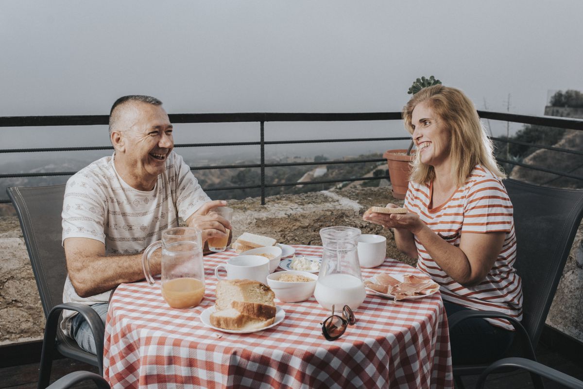 Personas desayunando en una terraza con vista al Teide, Tenerife.