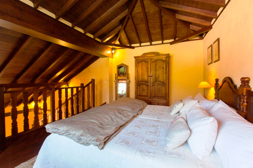 Habitación con cama grande, techo de madera y armario en Tenerife.