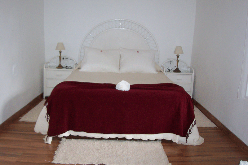 Cama doble con manta roja en una habitación de hotel en Tenerife.