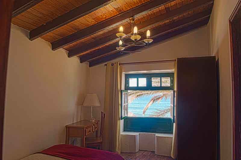 Habitación con ventana abierta y vista al mar en Tenerife.