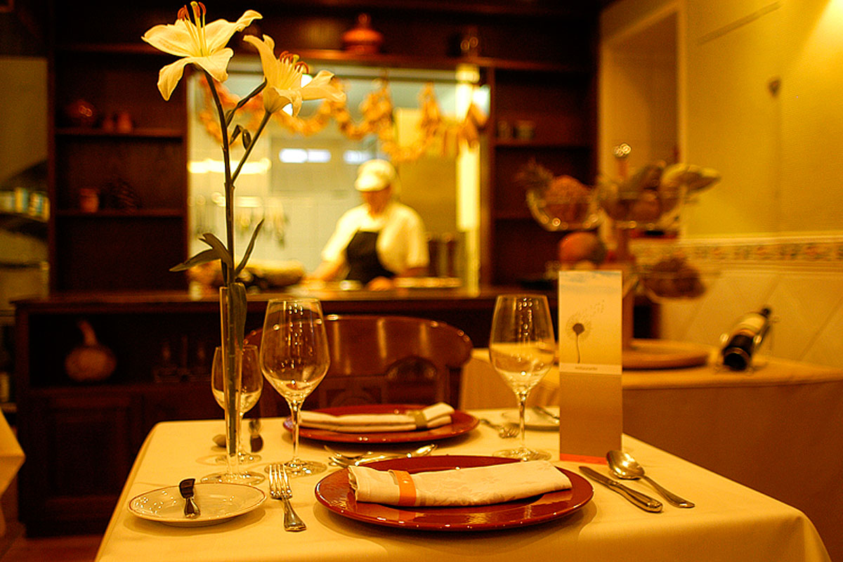 Mesa con copas, platos y flores en restaurante con chef en Tenerife.