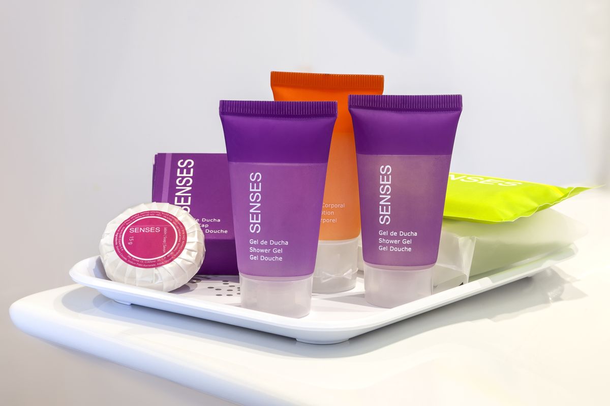 Productos de baño SENSES, gel de ducha y jabón en envases coloridos sobre bandeja.