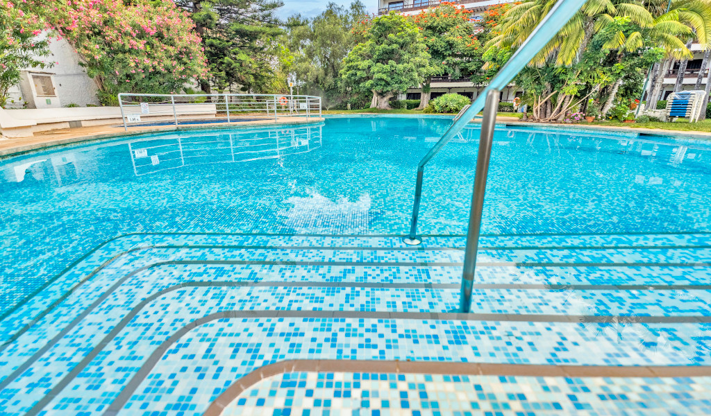 Escalera que desciende a una piscina rodeada de vegetación en Tenerife.