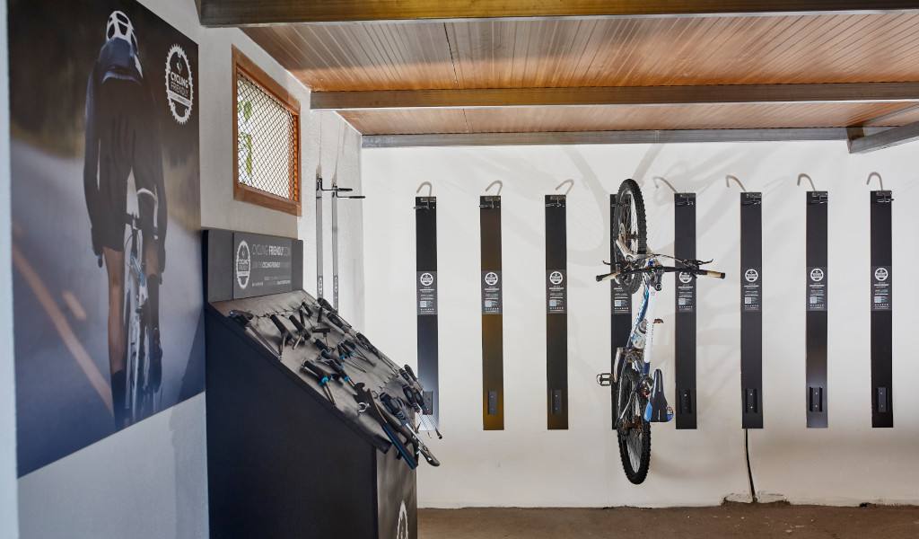 Bicicleta colgada en garaje con accesorios de ciclismo en exposición en Tenerife.