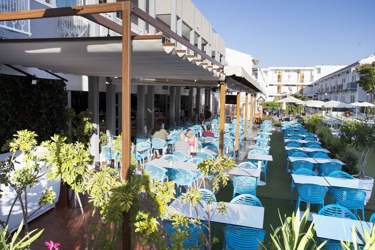 Terraza con mesas y sillas azules en un restaurante en Tenerife.