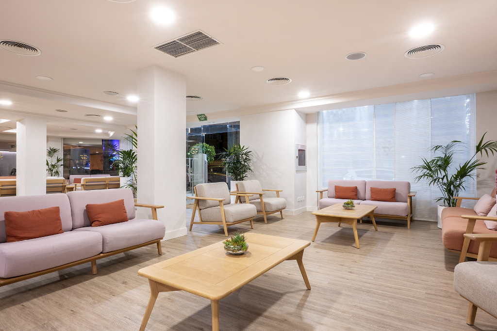Sala de espera con sofás y plantas en hotel de Tenerife.