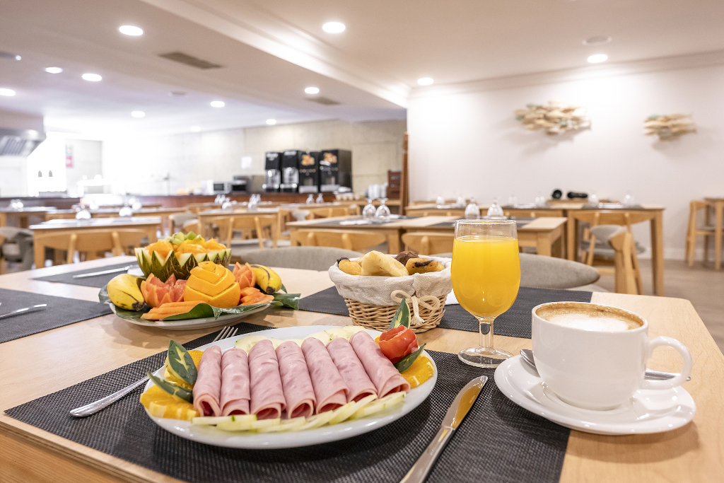 Desayuno con jamón, frutas tropicales y café en restaurante de Tenerife.