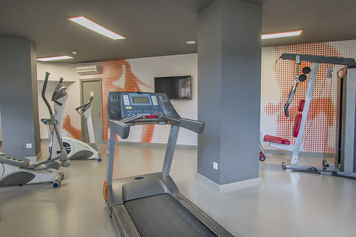 Equipo de gimnasio en un hotel en Tenerife con cinta de correr y bicicletas estáticas.