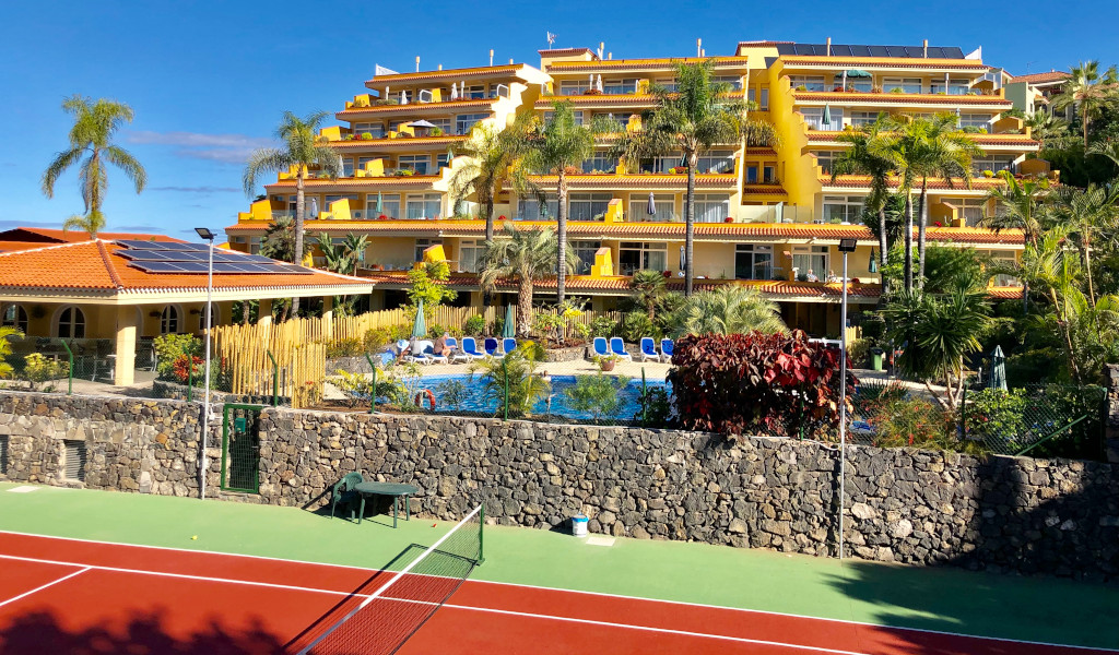 Complejo turístico con piscina y cancha de tenis en Tenerife.