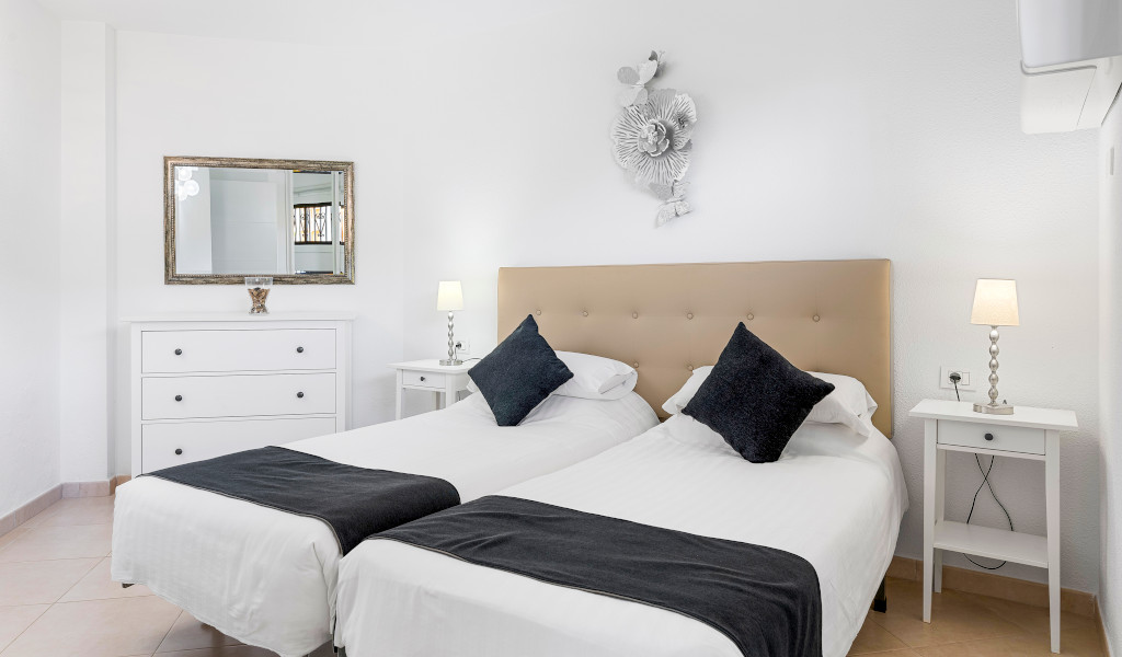 Dos camas individuales con cabecera y mesas de noche en habitación de Tenerife.