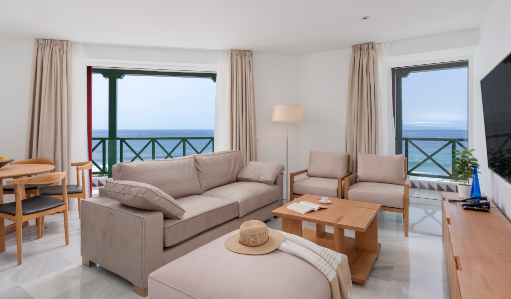 Sala de estar con vista al mar en un apartamento de Tenerife, sofá y mesa de centro.
