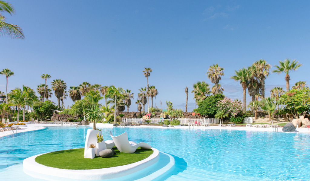 Piscina rodeada de palmeras en Costa Adeje, Tenerife.