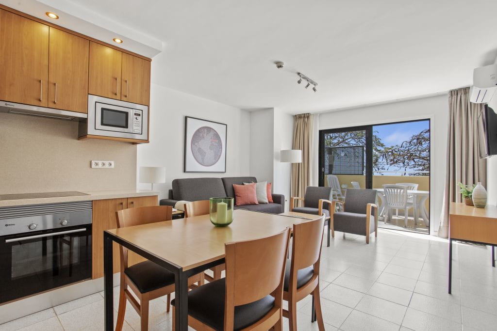 Sala de estar de apartamento con cocina, mesa y balcón en Tenerife.