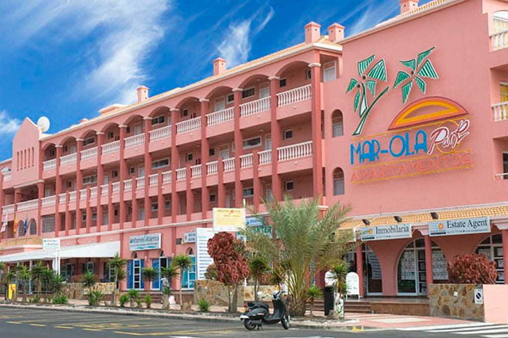 Mar-Ola Park Apartamentos en Tenerife con fachada rosa y palmeras.