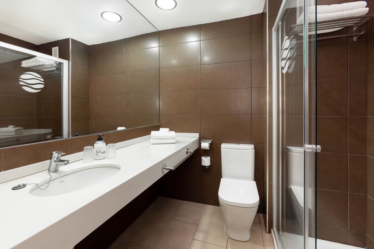 Baño moderno con lavabo, inodoro y ducha en hotel de Tenerife.