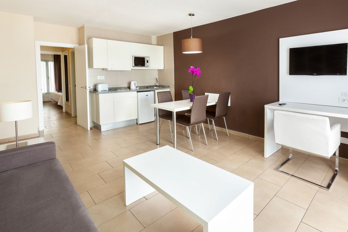 Sala de estar con cocina y comedor en un apartamento en Tenerife.