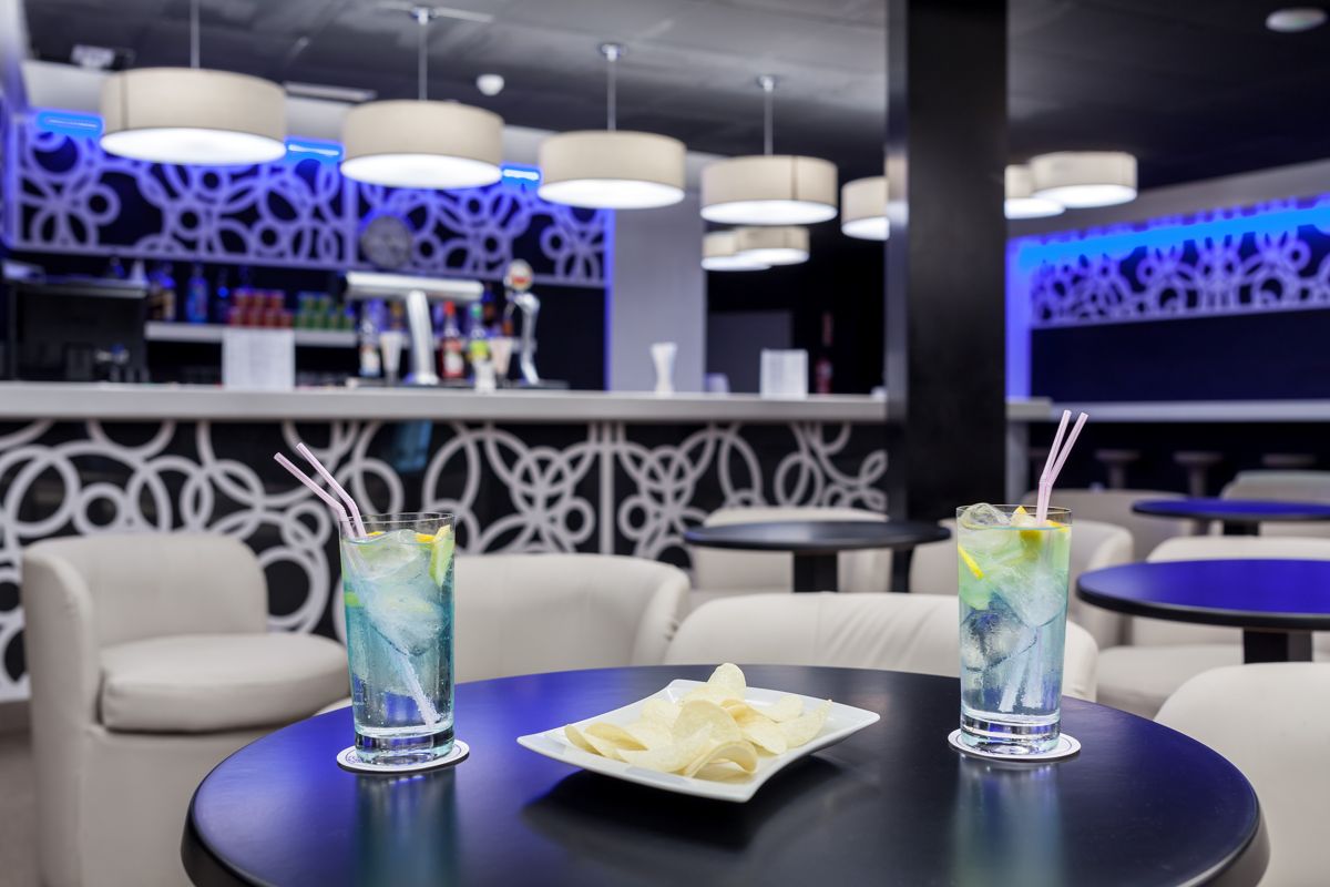 Cócteles y papas en una mesa en bar moderno en Tenerife.