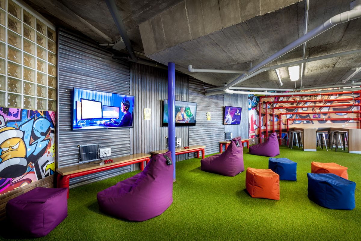 Sala de juegos con puffs, pantallas y grafitis en Tenerife.