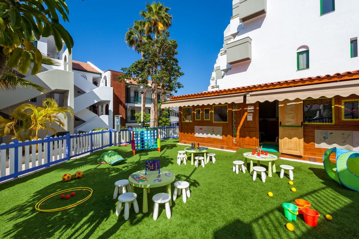 Patio de juegos con mesas y juguetes en complejo turístico de Tenerife.