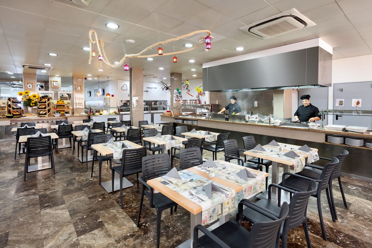 Restaurante con mesas preparadas y chefs cocinando en Tenerife.