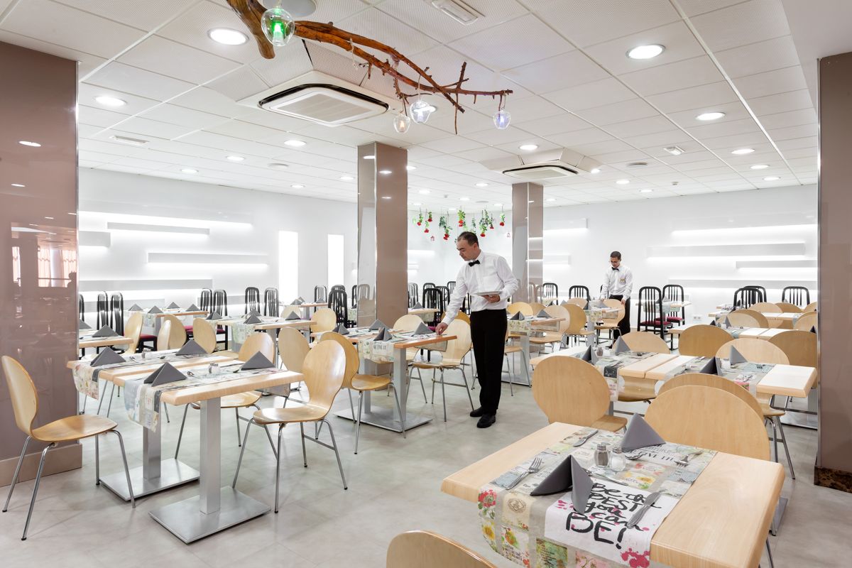 Restaurante con mesas preparadas y dos camareros en Tenerife.