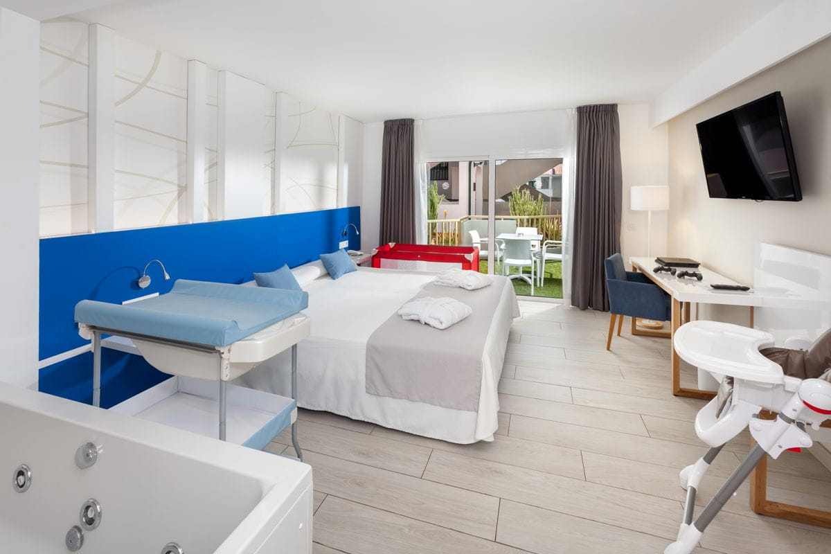 Habitación de hotel familiar con terraza en Tenerife, equipada con cuna y jacuzzi.