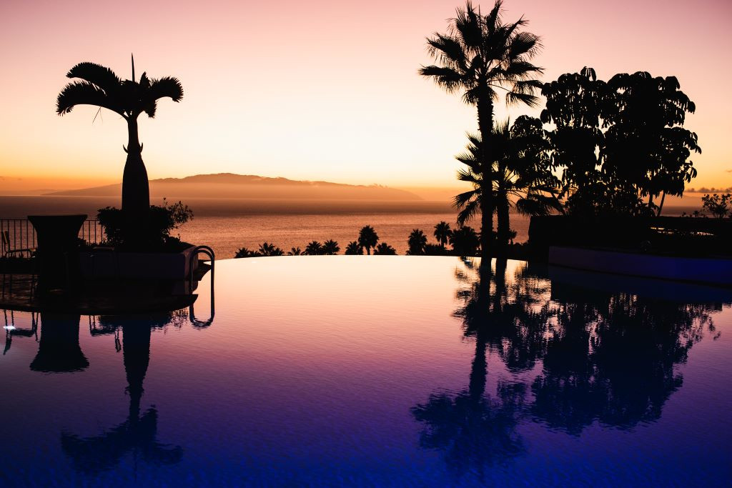 Atardecer sobre piscina infinita y mar en Tenerife.