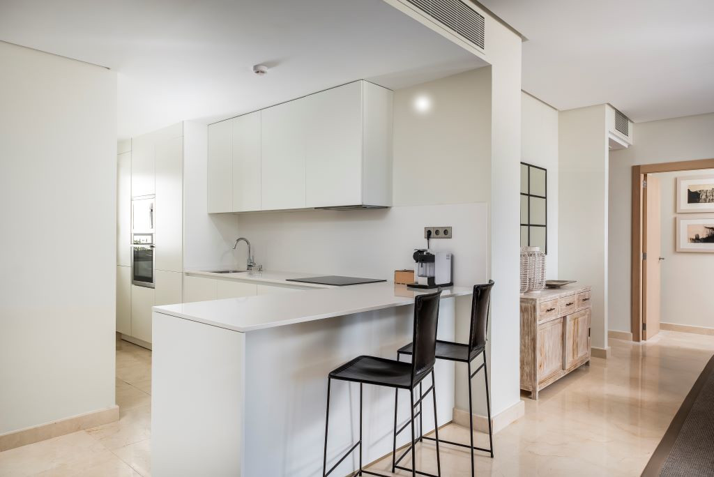 Cocina moderna en apartamento de Tenerife con barra y sillas altas.