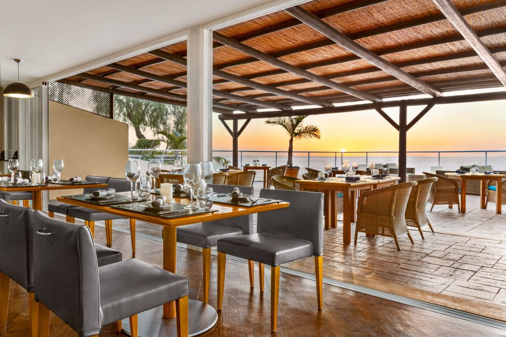 Restaurante al aire libre al atardecer en Tenerife con mesas servidas.
