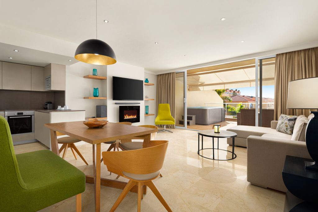 Sala de estar moderna con cocina integrada y acceso a terraza en Tenerife.
