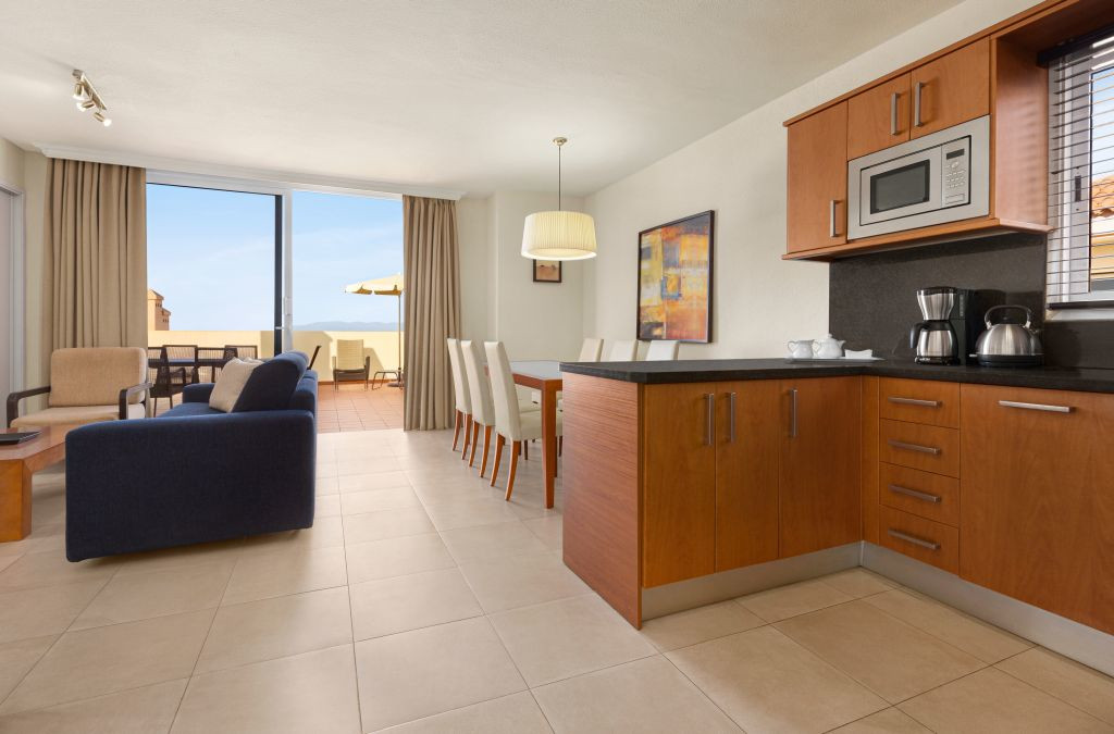 Sala de estar y cocina moderna con balcón con vista al mar en Tenerife.