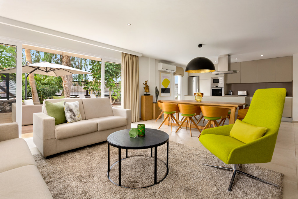 Sala de estar moderna con comedor y cocina en Tenerife, amplia vista al jardín exterior.