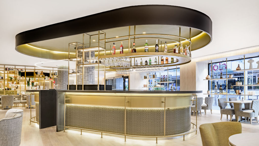 Barra de bar moderna con botellas y copas, diseño luminoso en Tenerife.
