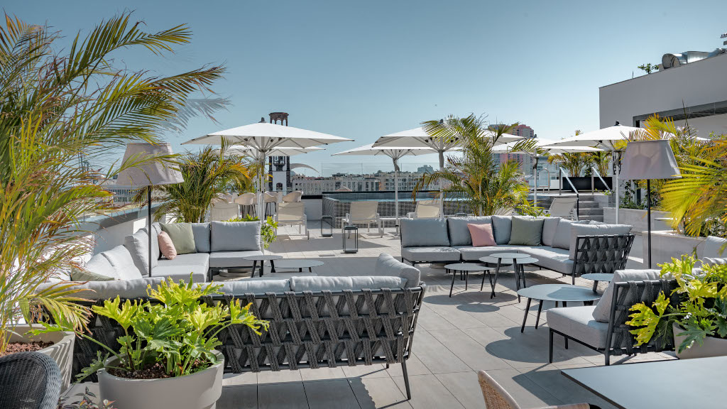 Terraza con sofás, sombrillas y plantas en un hotel de Santa Cruz de Tenerife.