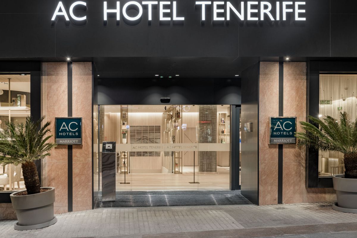 Entrada al AC Hotel Tenerife en la calle iluminada por la noche.