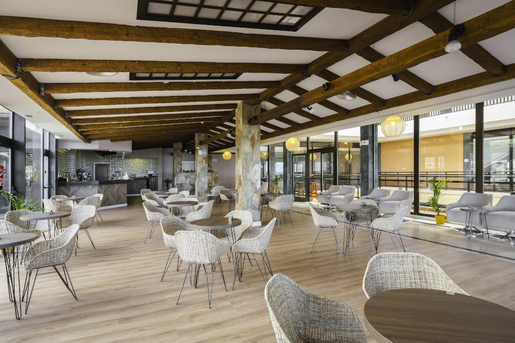Cafetería amplia con sillas y mesas de mimbre en Tenerife.
