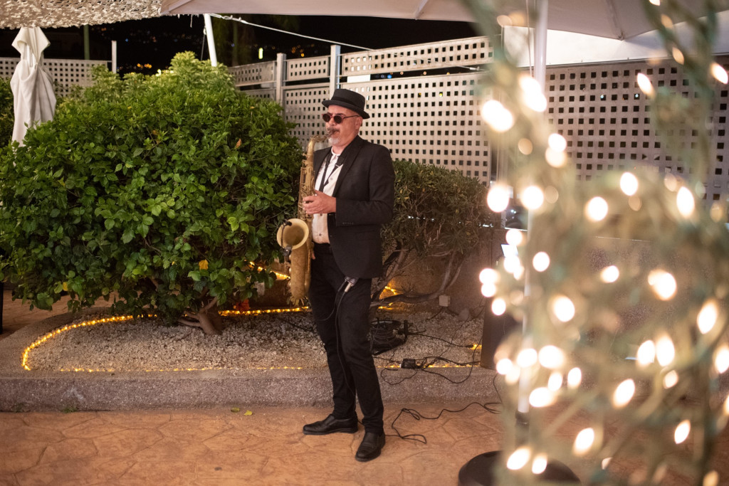 Músico tocando saxofón en un jardín iluminado en Tenerife.