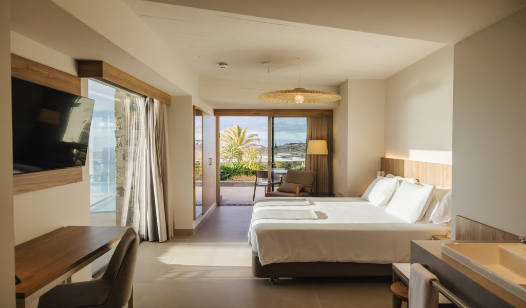 Habitación de hotel con una cama doble y vista al exterior en Tenerife.