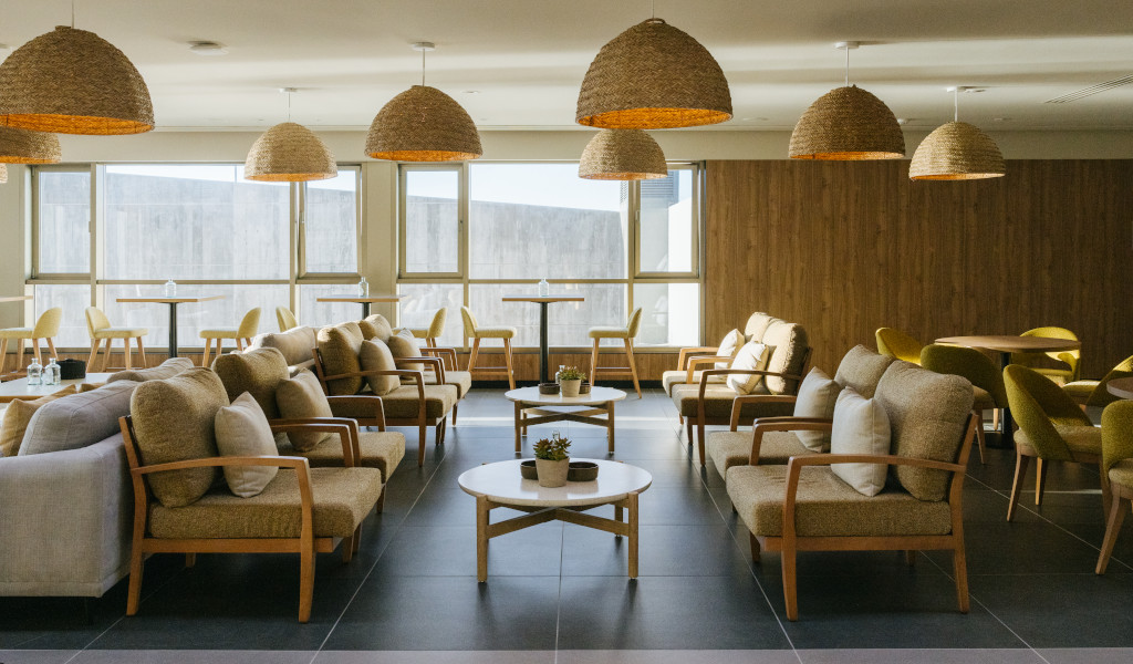 Sala de estar con sillones y mesas de madera en un hotel de Tenerife.
