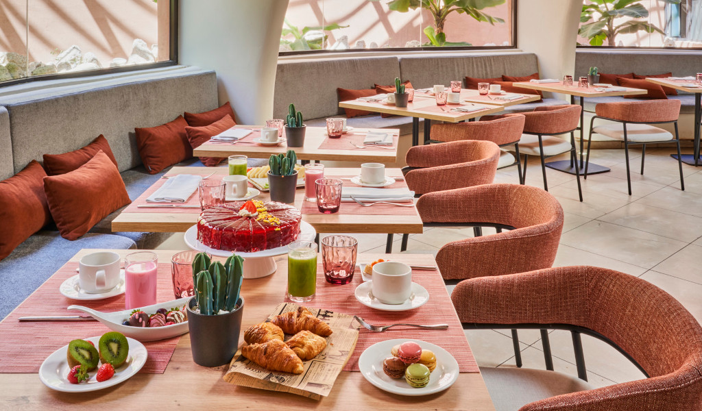 Mesas de desayuno con pasteles y bebidas en un restaurante en Tenerife.