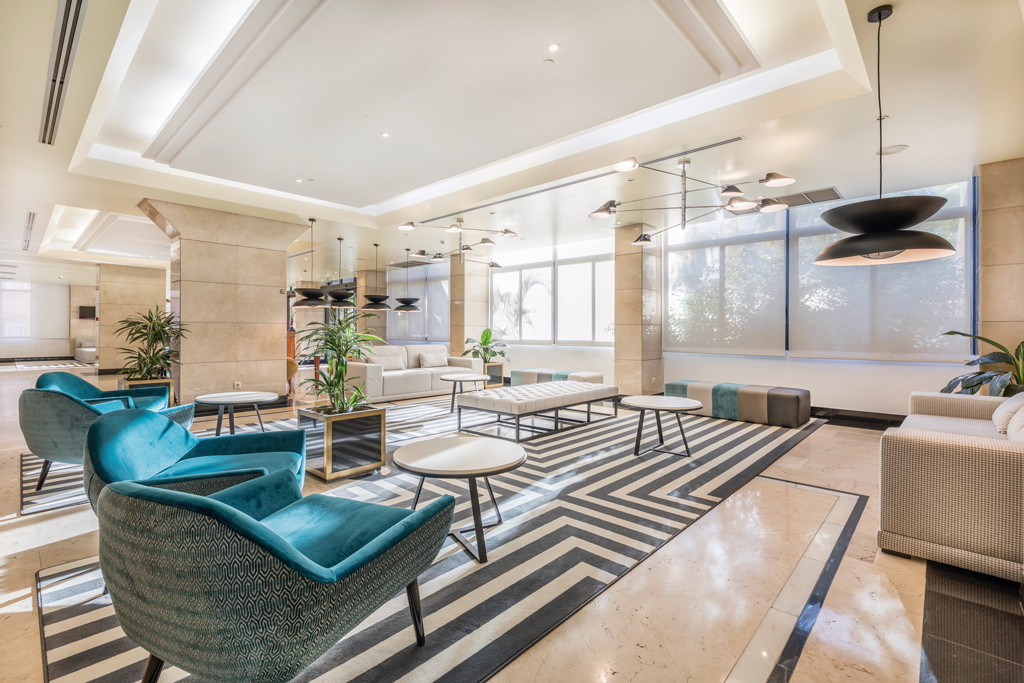 Sala de estar moderna con sillas azules y mesas redondas en Tenerife.