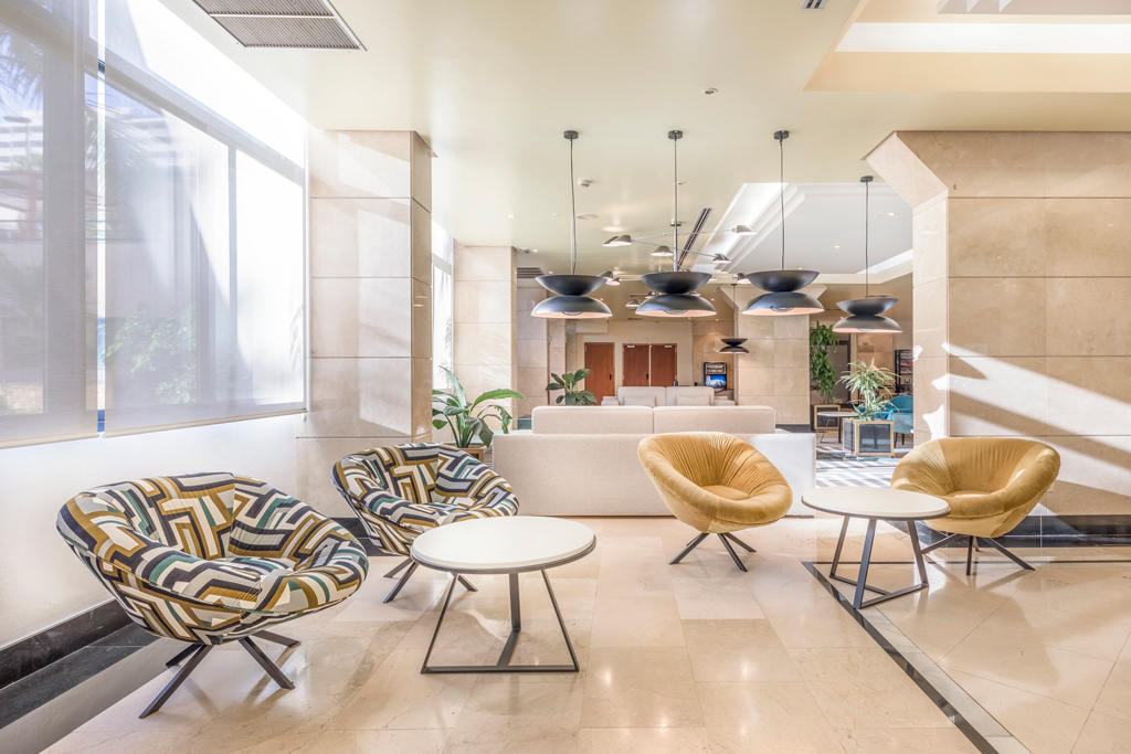Sala de estar moderna con sillones y mesas en un hotel de Tenerife.