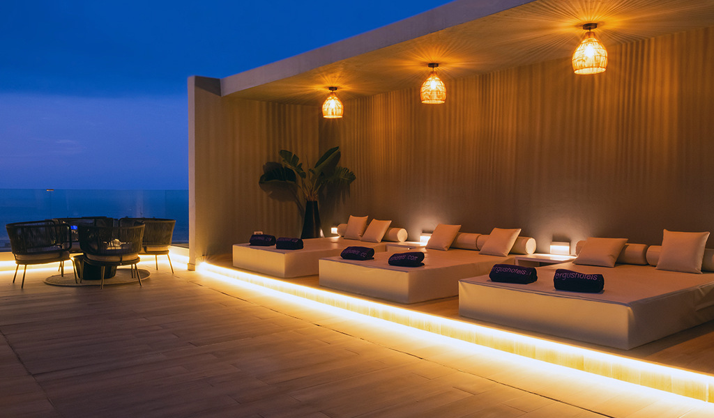 Terraza iluminada con camas y toallas de FERGUS Hotels en Tenerife.