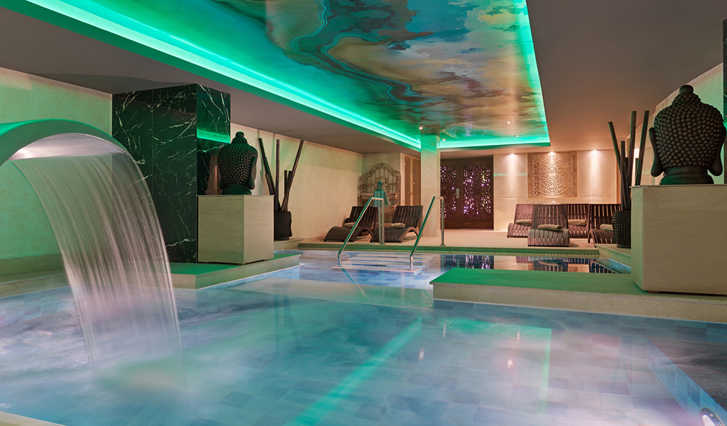 Piscina interior con cascada y esculturas en spa de Tenerife.
