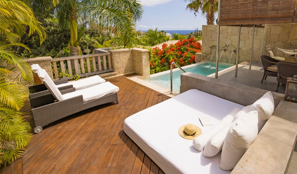 Terraza en Tenerife con piscina pequeña, tumbonas y vegetación tropical.