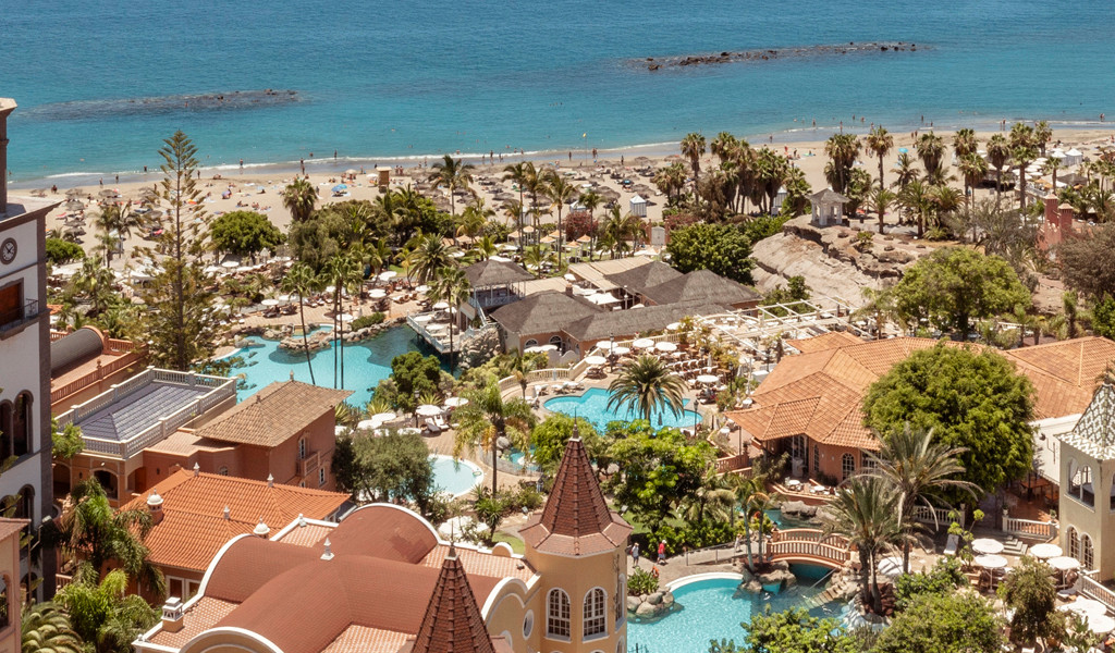 Vista aérea de un complejo hotelero con piscina y playa en Costa Adeje, Tenerife.
