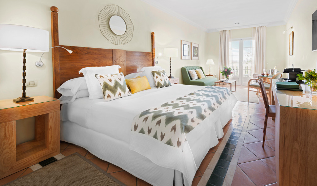 Habitación luminosa con cama doble y escritorio, vista al jardín en Tenerife.